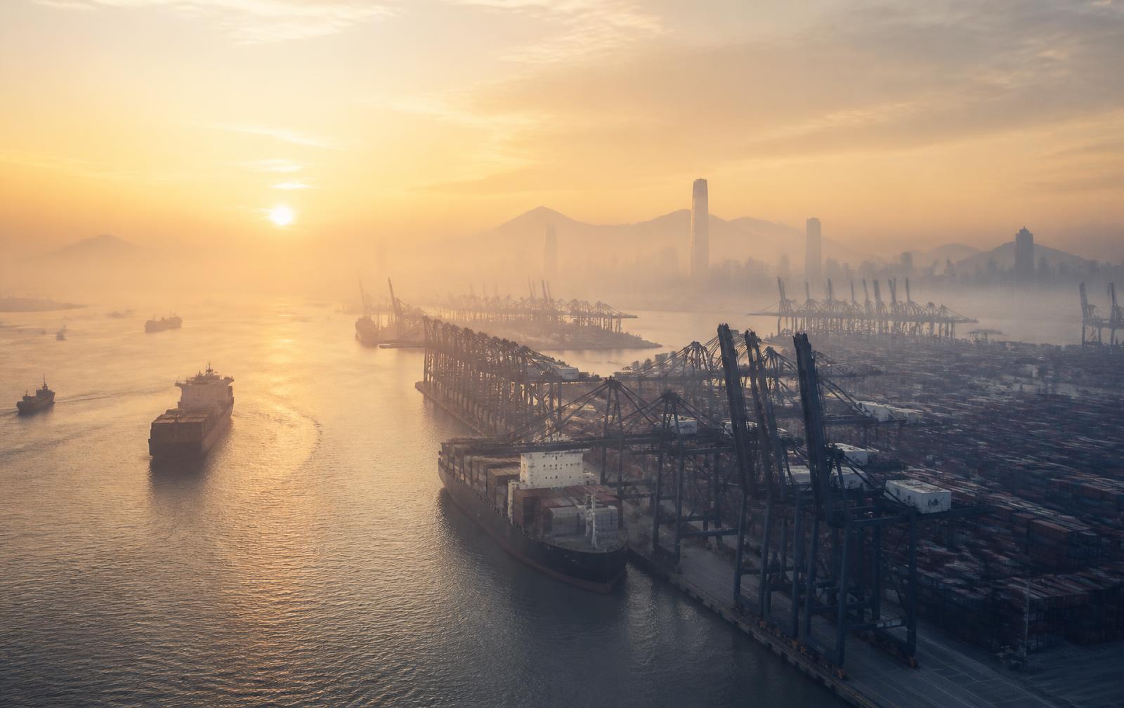 Porto de Shenzhen ao amanhecer com guindastes e navios cargueiros